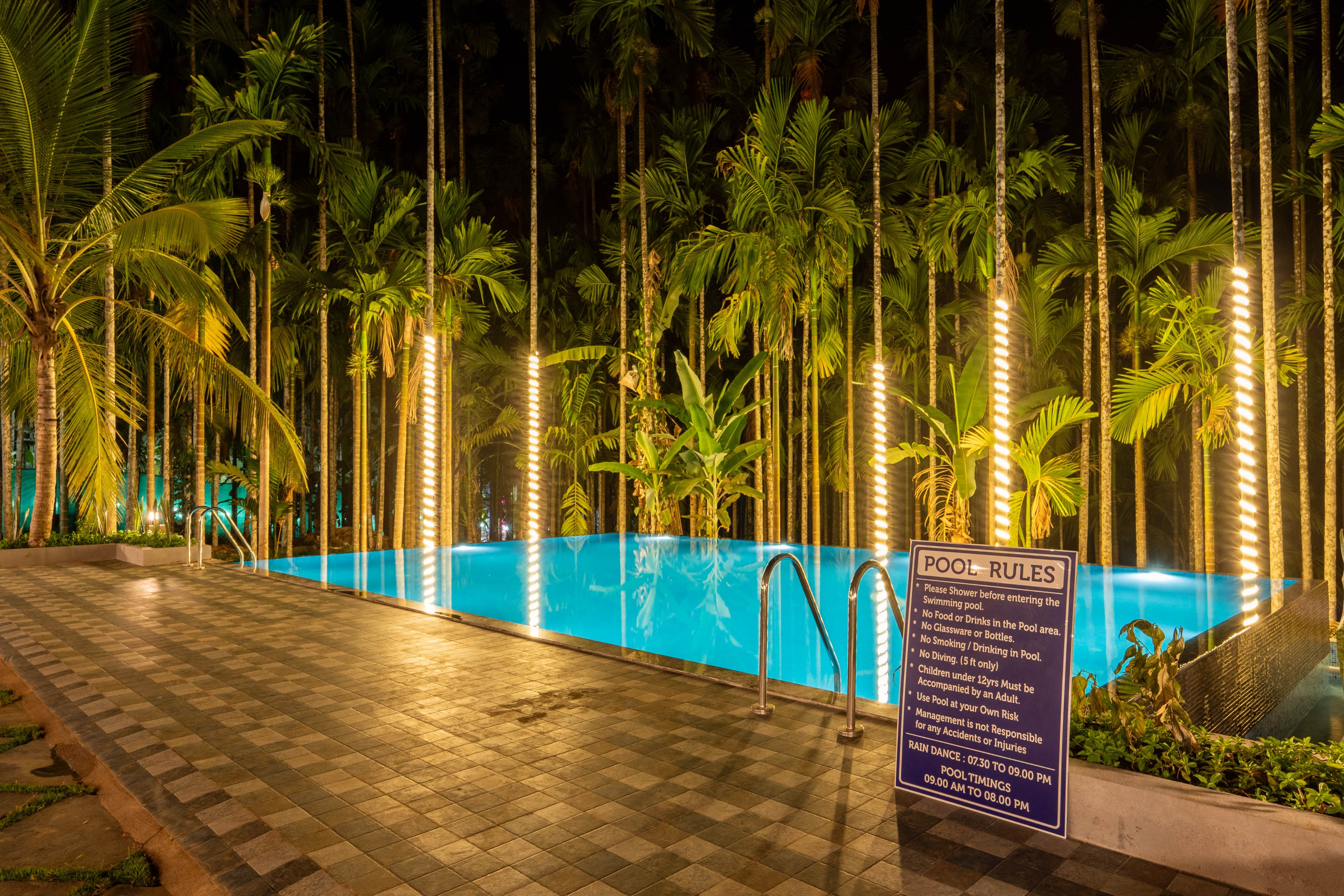Close-up of the swimming pool with pool rules sign at night