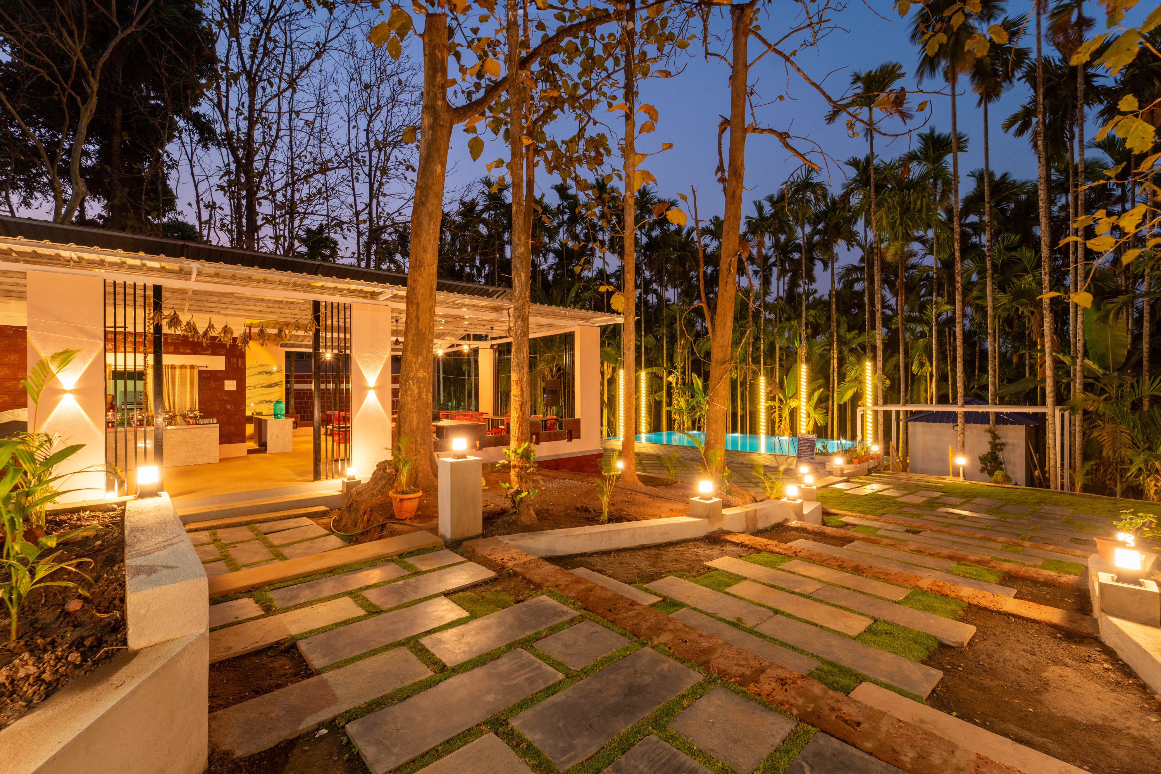 Pathway and pool area illuminated at dusk at our Dandeli resort
